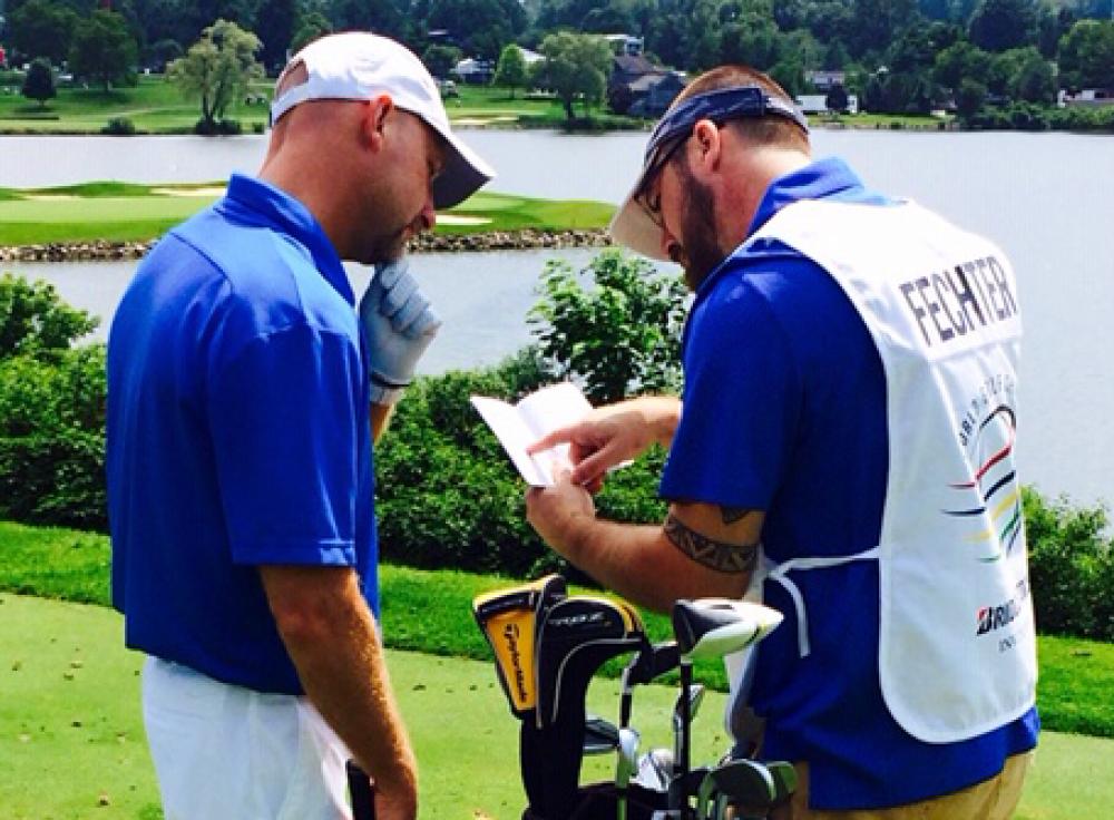 dave and his caddy examining the score card