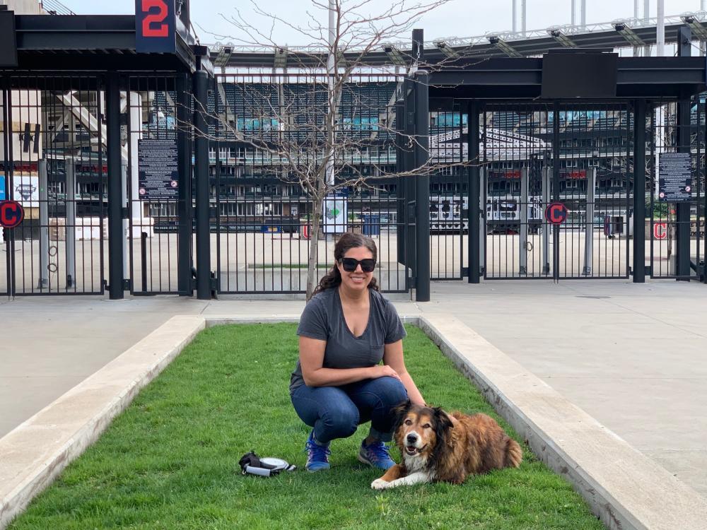 young woman with dog at a baseball stadium