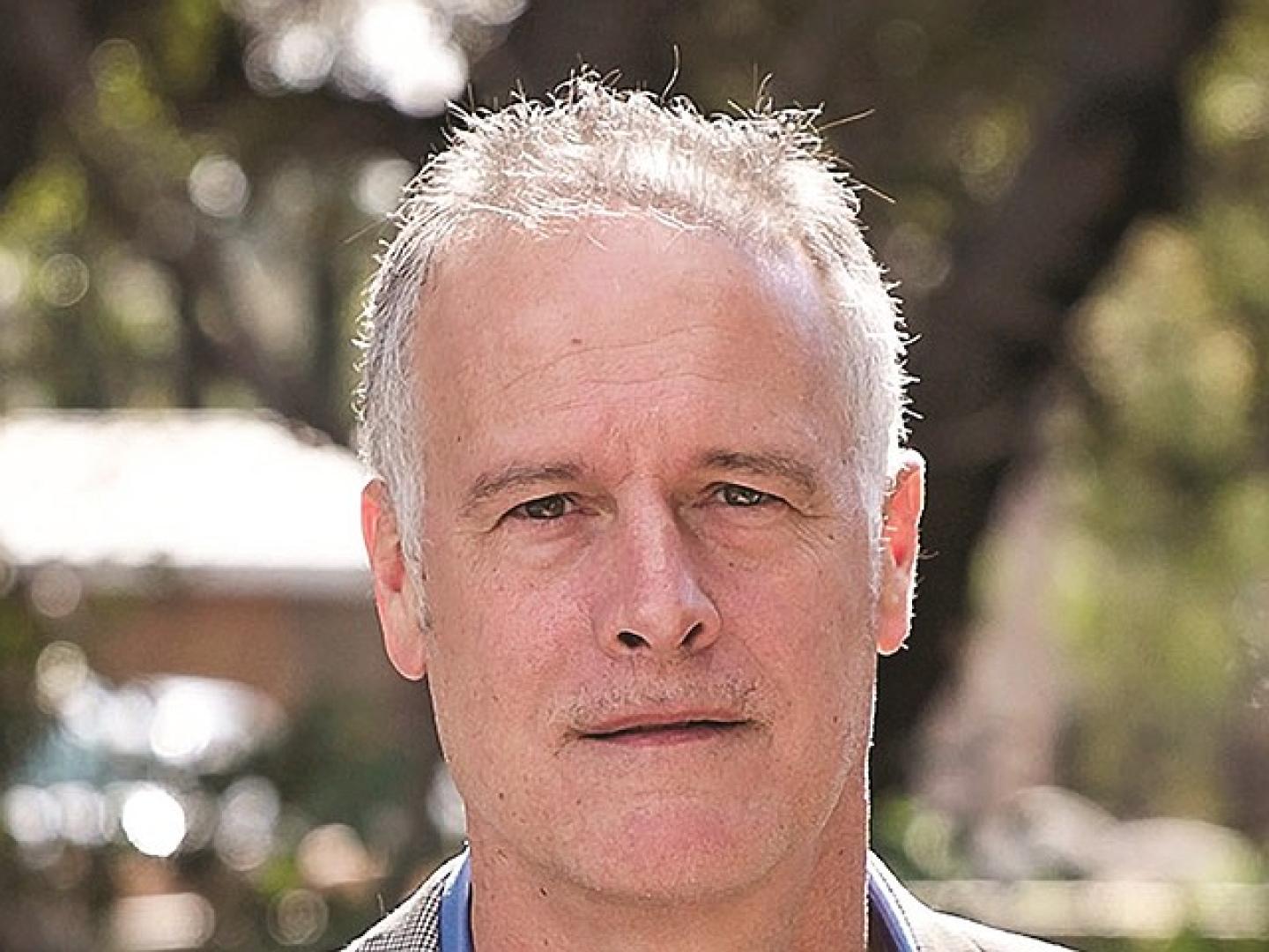 a headshot of panelist Mike Dokomanovich, an older white man.