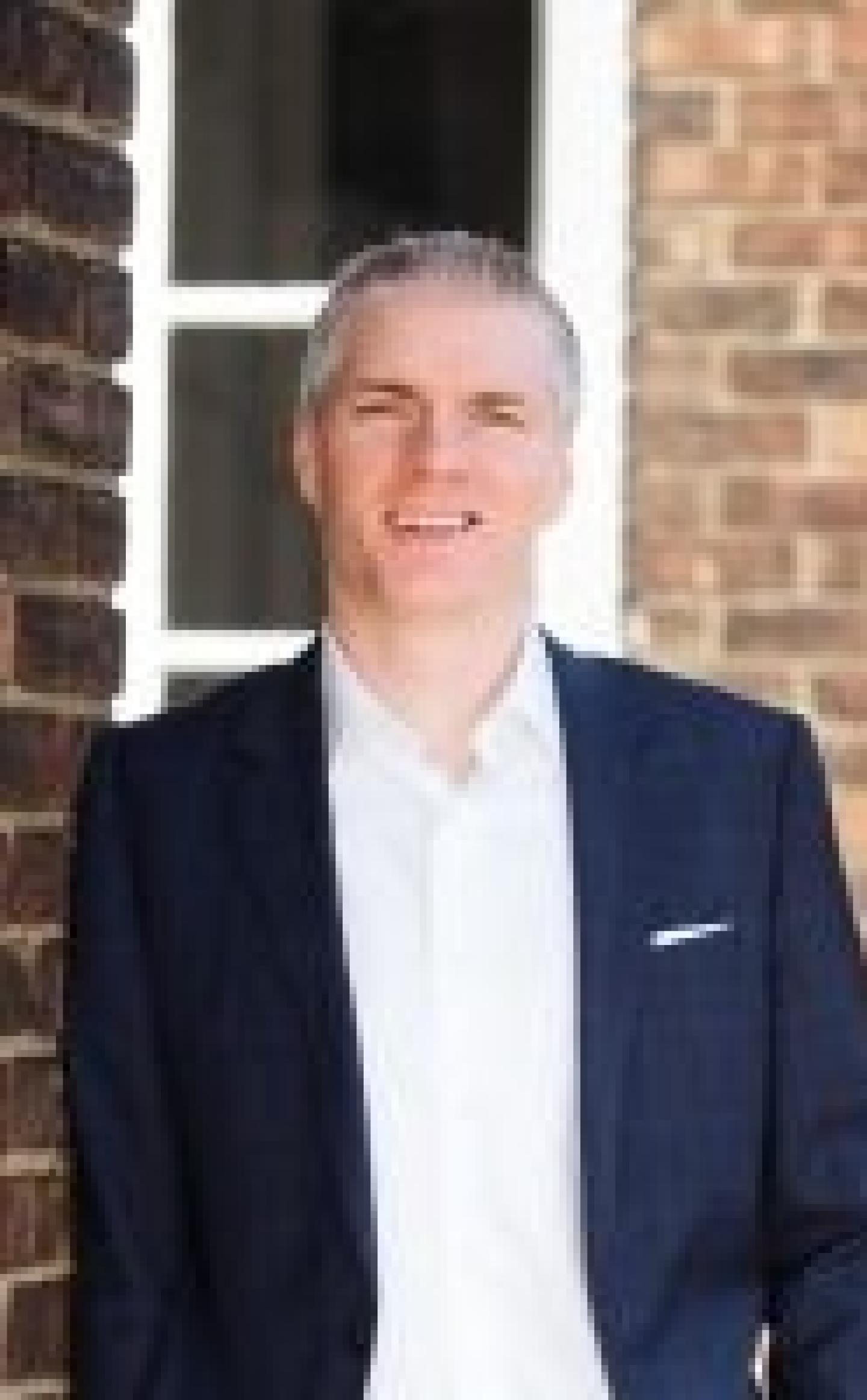 Smiling man in white shirt and blue jacket