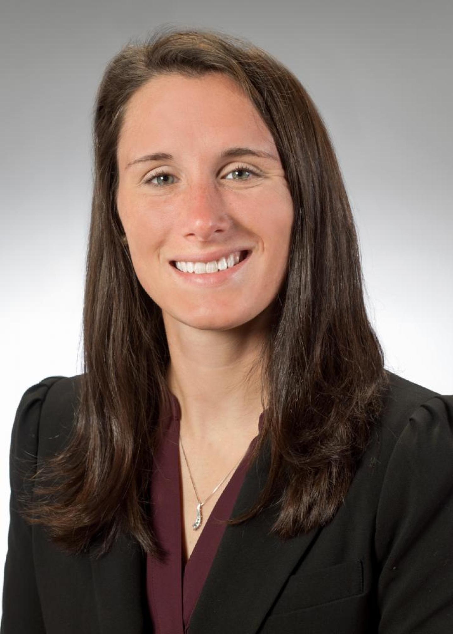 smiling woman in dark suite on light background