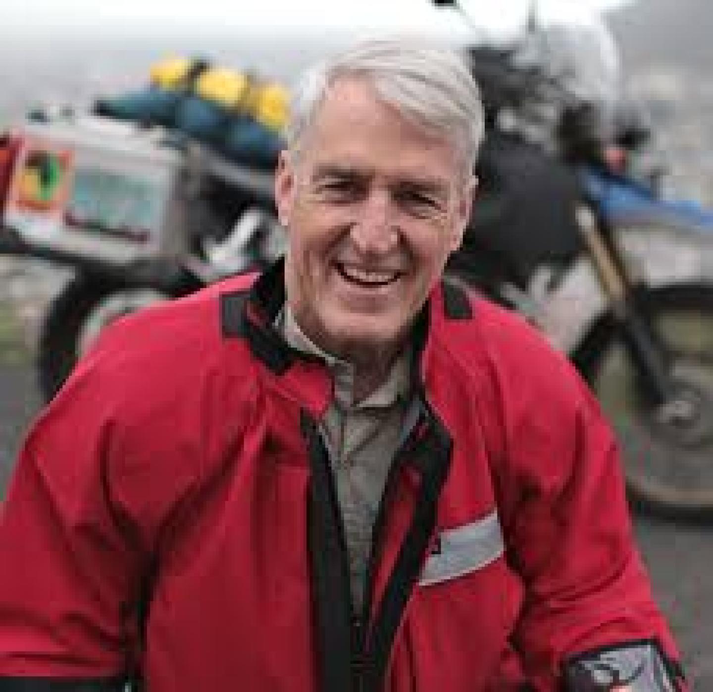 smiling man in a red motorcycle jacket