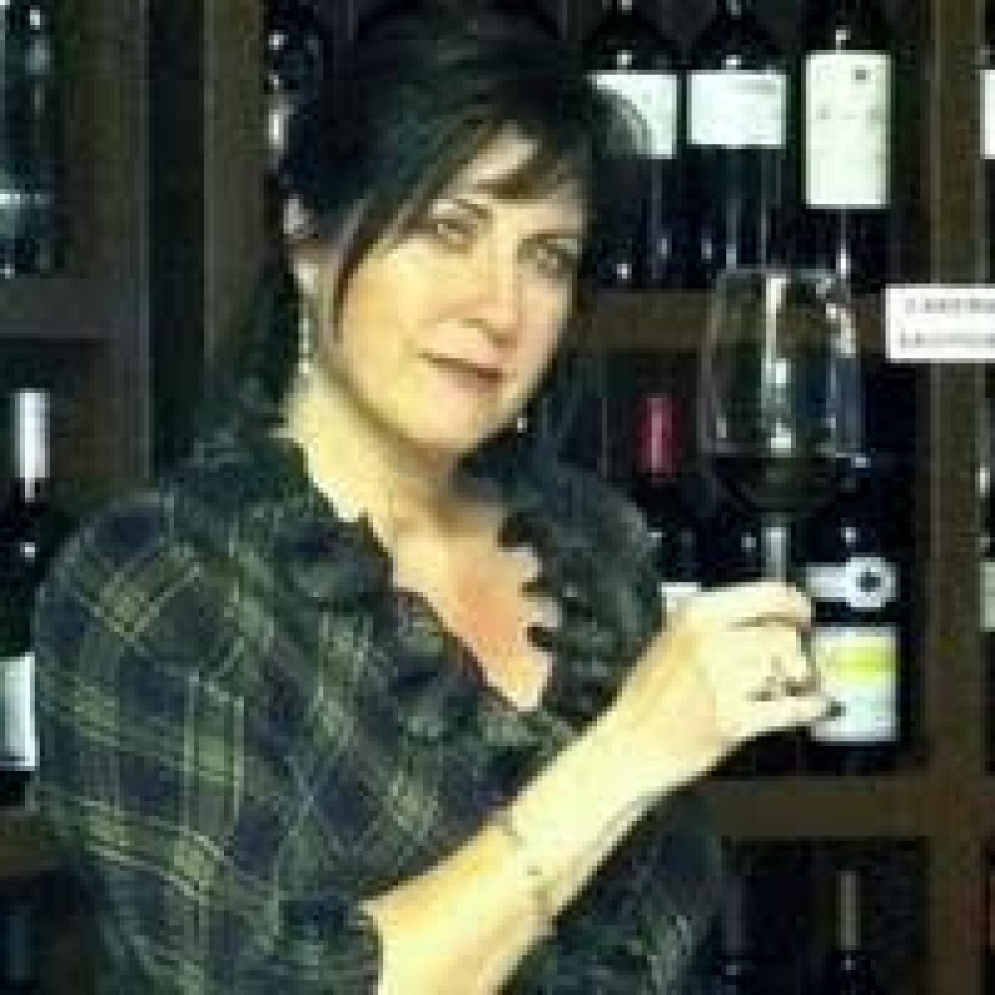 woman standing in front of a wall of wine