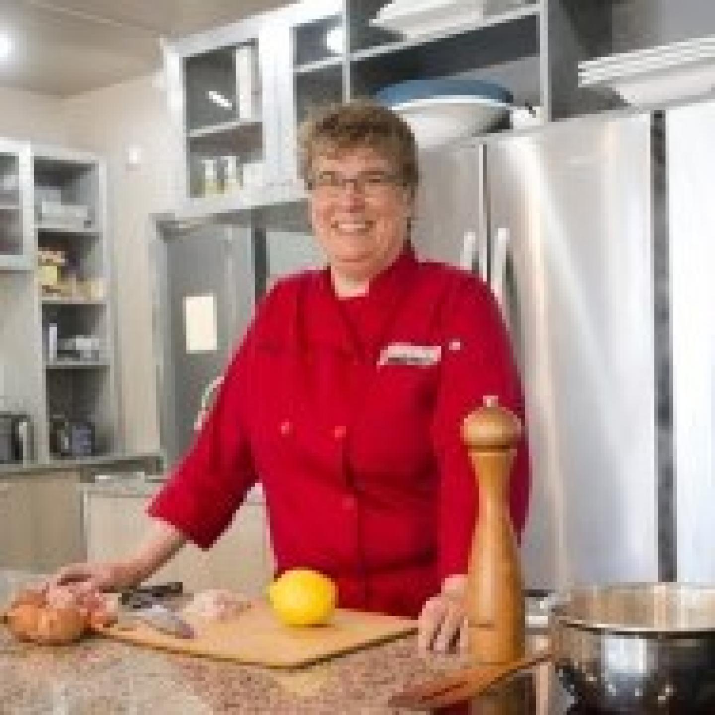 smiling woman in red chef's coat